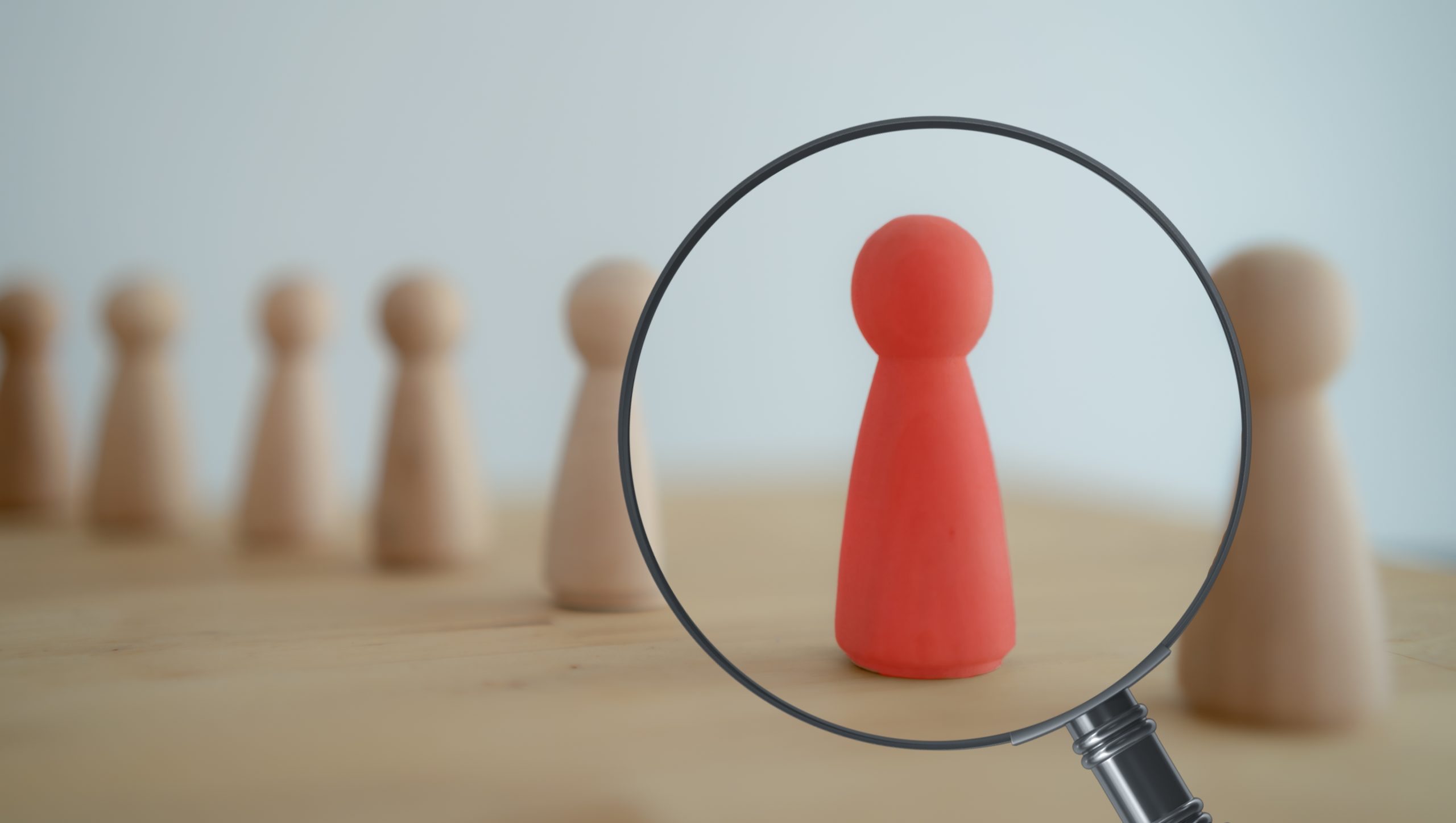 Magnifying glass and a red wooden person.